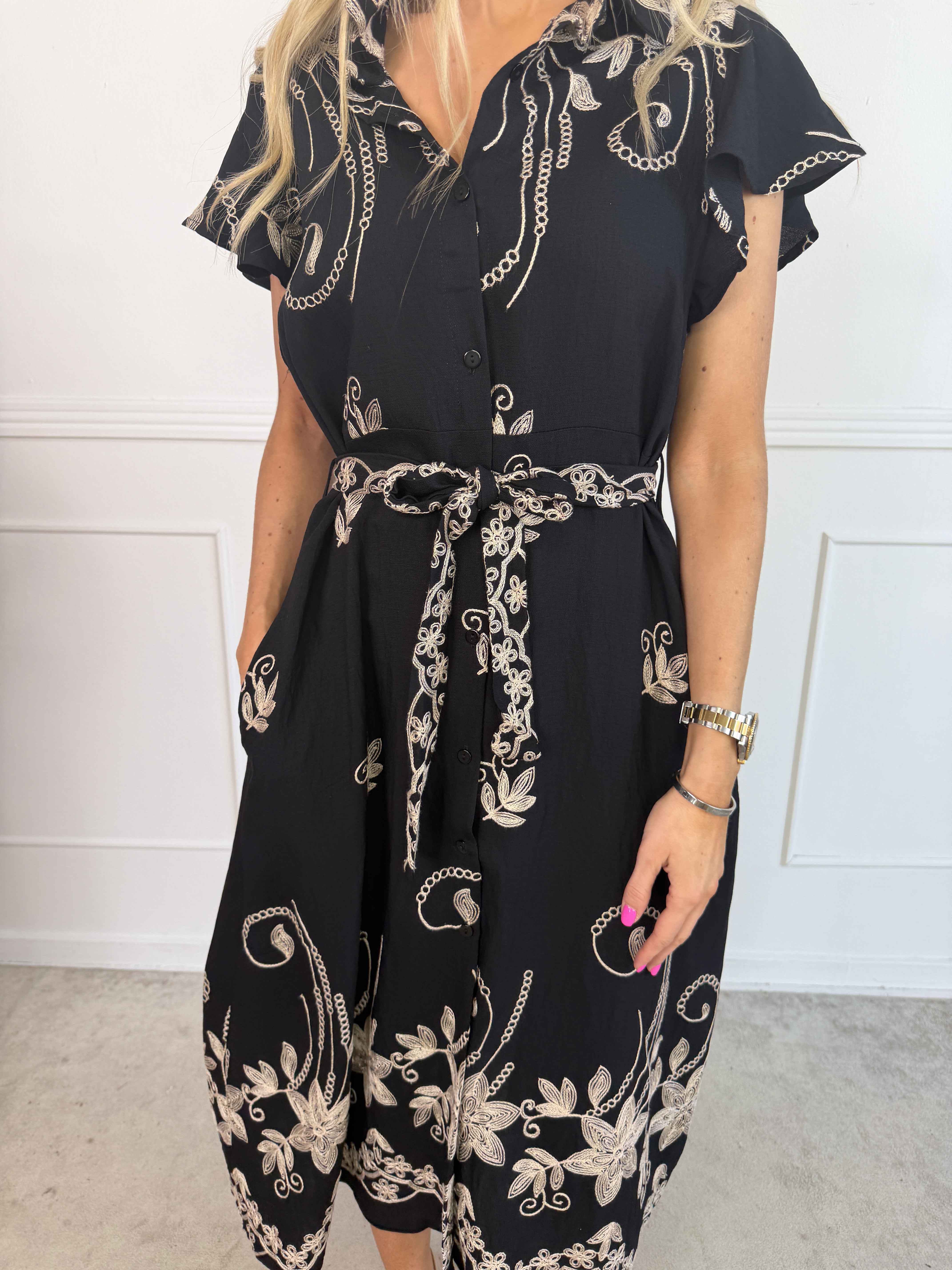 Marianne - Skjortklänning i viskos med broderade detaljer och volangärmar.